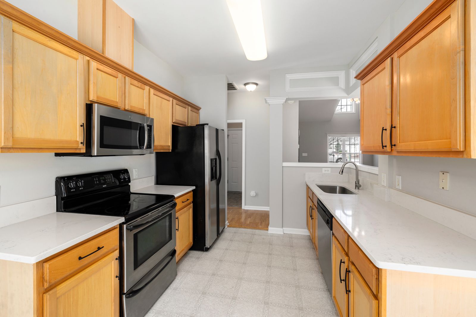 Pale patterned floor in a galley kitchen with light wood cabinets