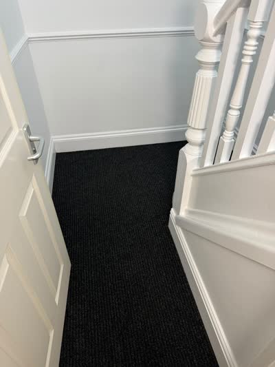 Charcoal carpet fitted on a landing by a white bannister