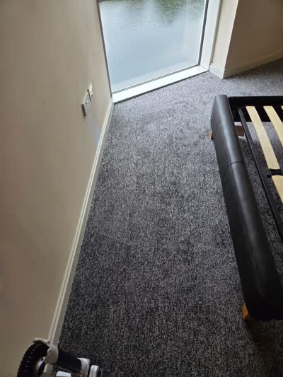 Grey carpet fitted in a bedroom with a frosted window