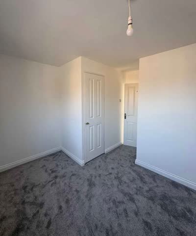 New grey carpet fitted in an empty room with white doors