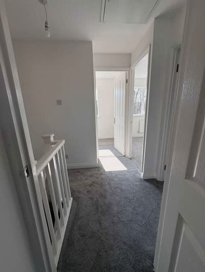 Grey carpet fitted along a landing and corridor with white doors